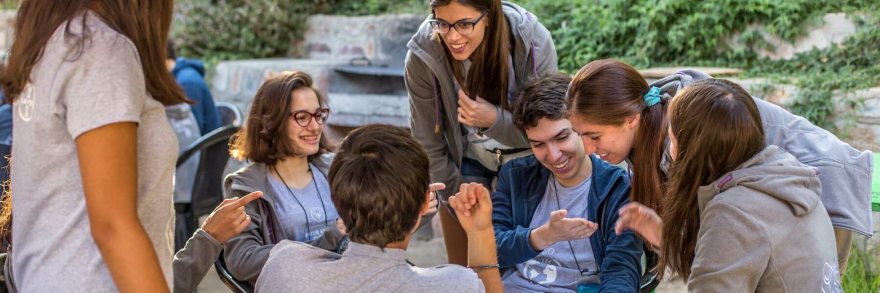 Imagen de jóvenes sentados en grupo sonriendo